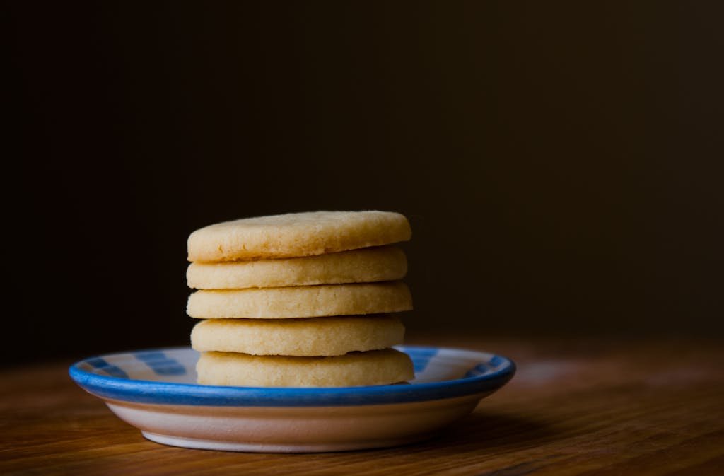 A stack of golden butter cookies on a ceramic plate, perfect for dessert inspiration.